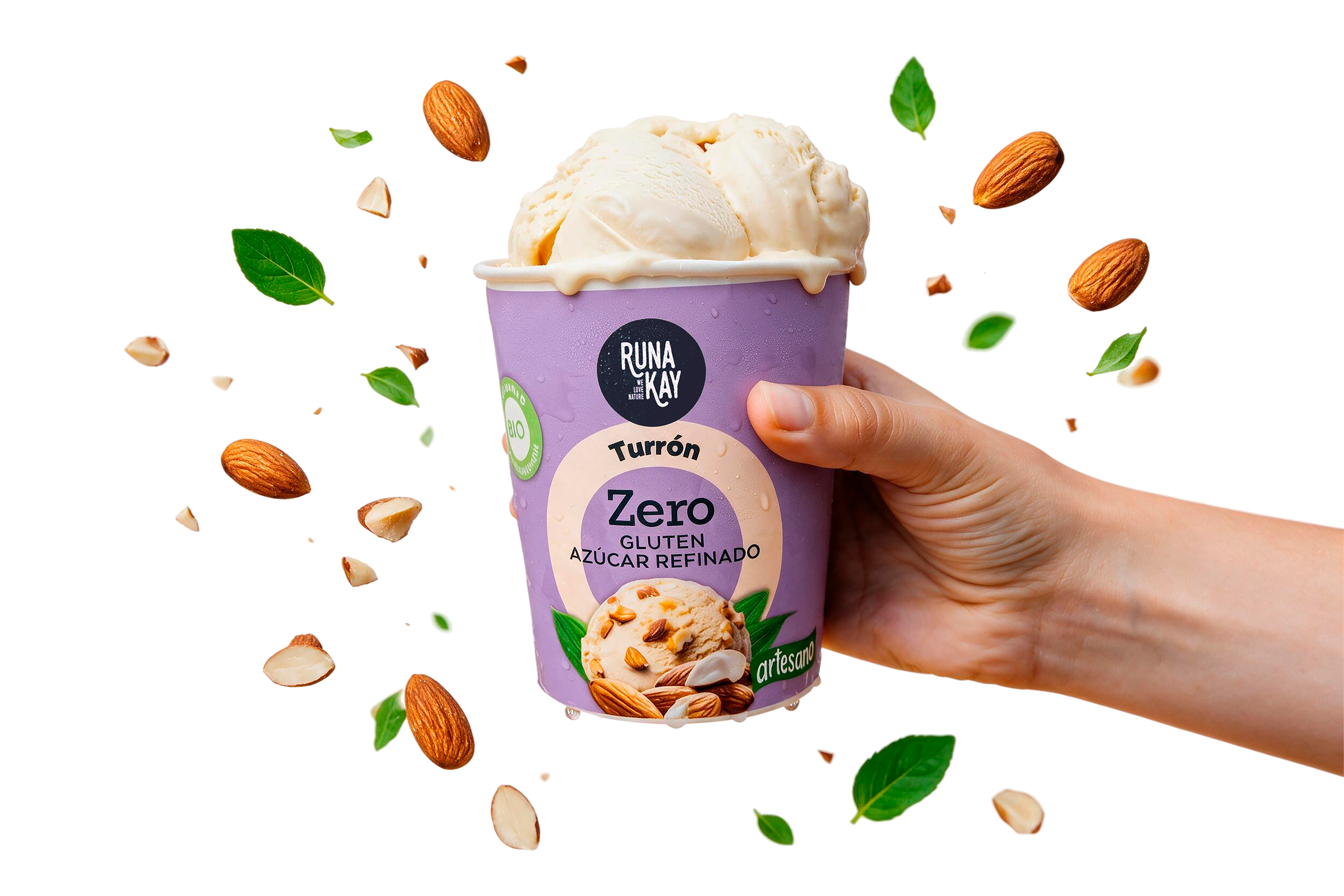 Mano sosteniendo una tarrina de helado artesano Runakay sabor Turrón, con almendras y hojas de menta volando alrededor